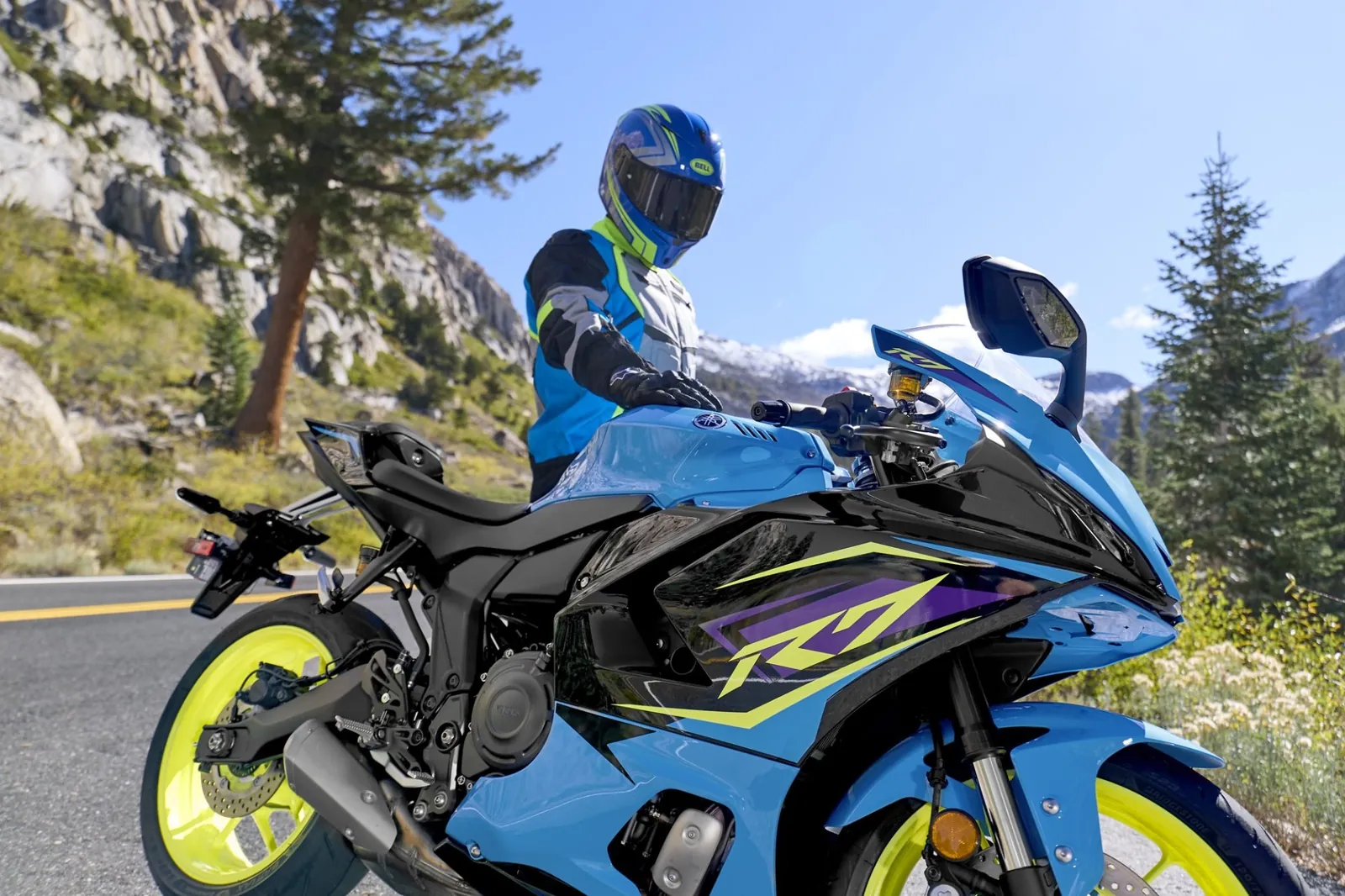 Rider on a sport motorcycle stopped on a mountain pass road